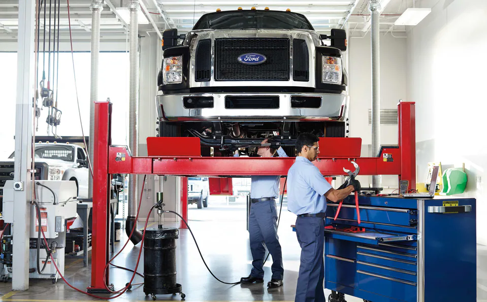 Two men working on a truck in a garage.