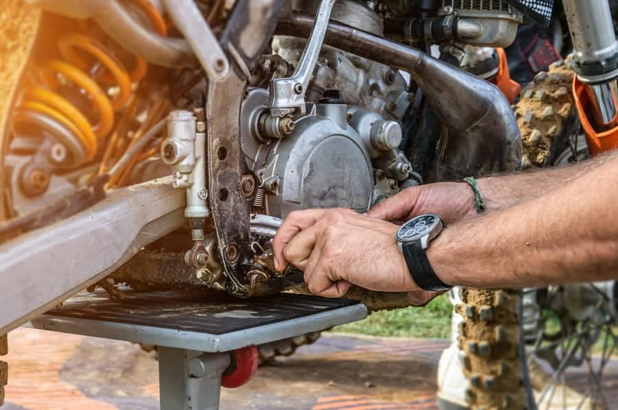 A person working on the engine of a motorcycle.