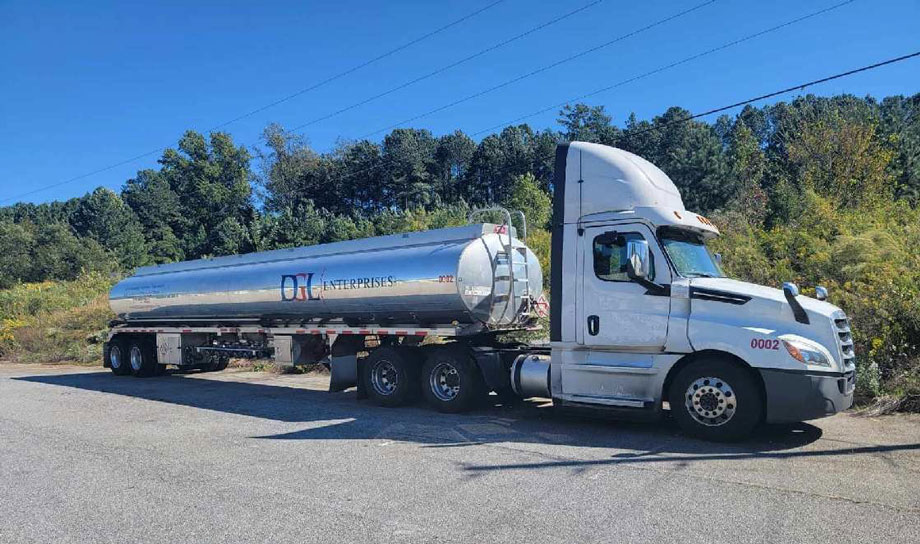 A white truck with a silver tanker trailer.